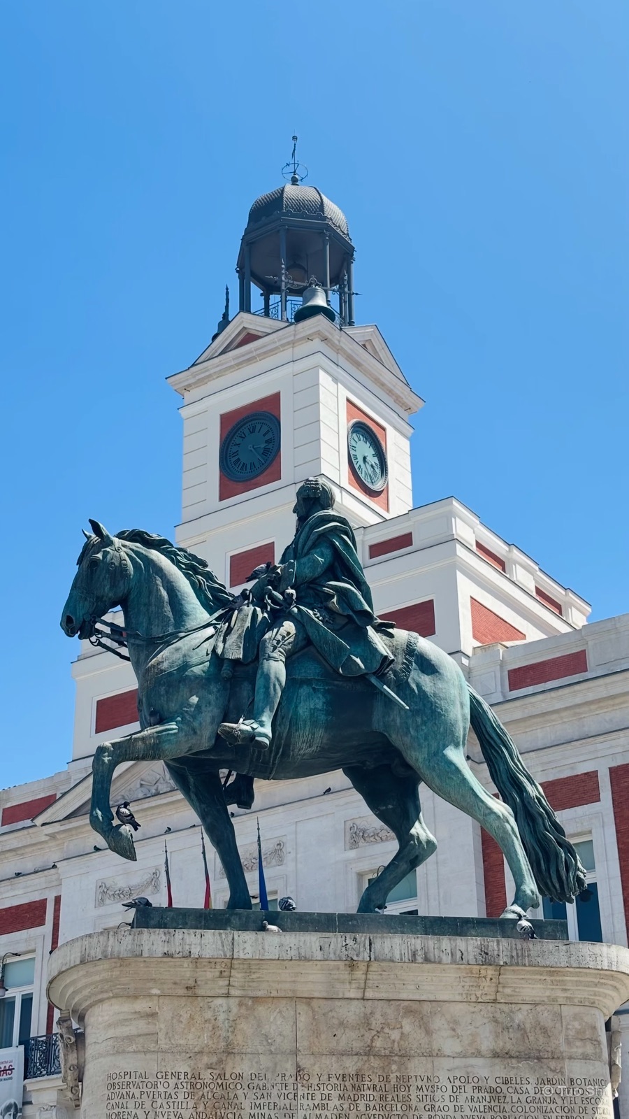 Bronze statue of Carlos III on horseback in front of the clock tower at Puerta del Sol