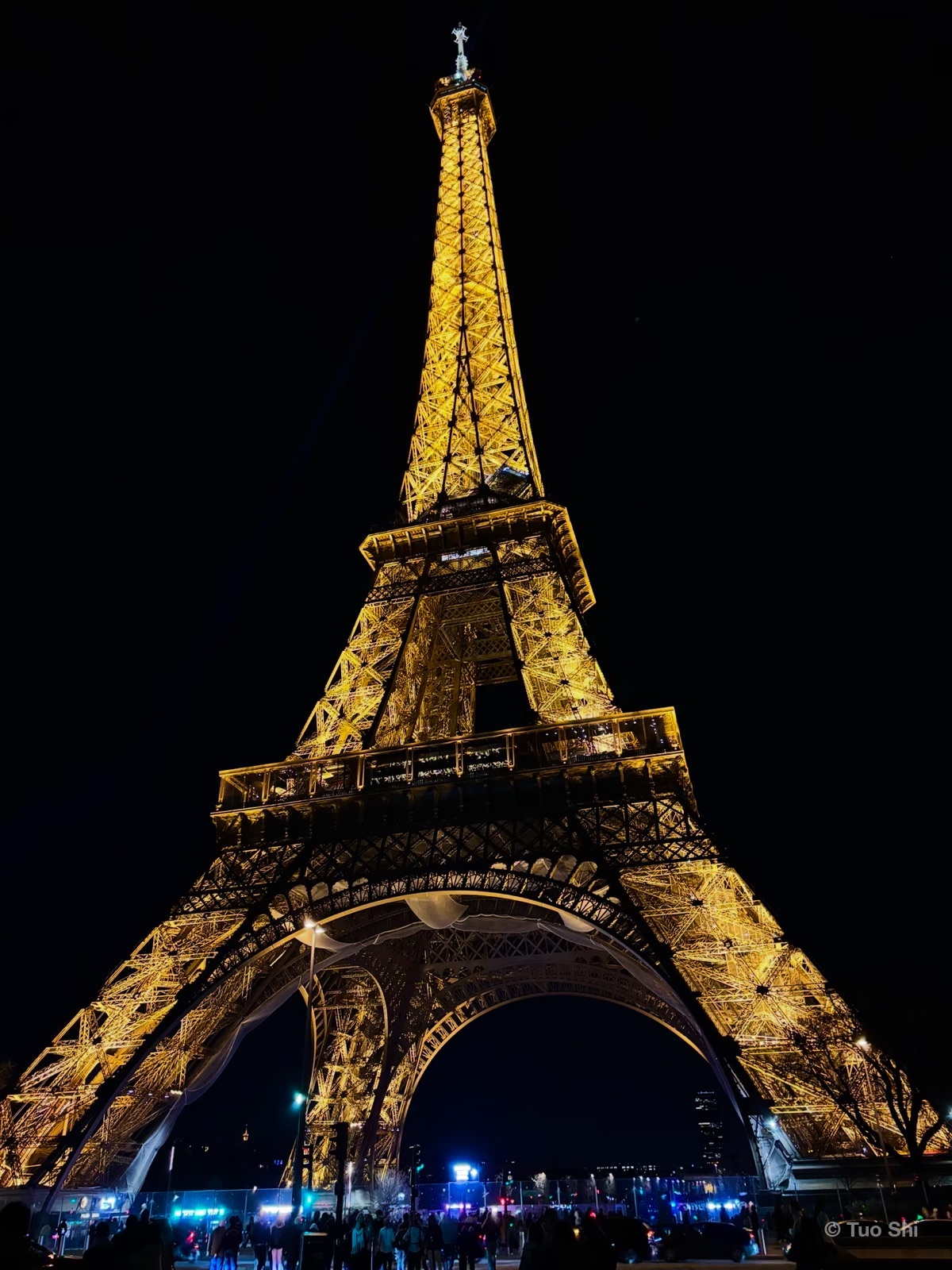 The Eiffel Tower lit in gold against the night sky