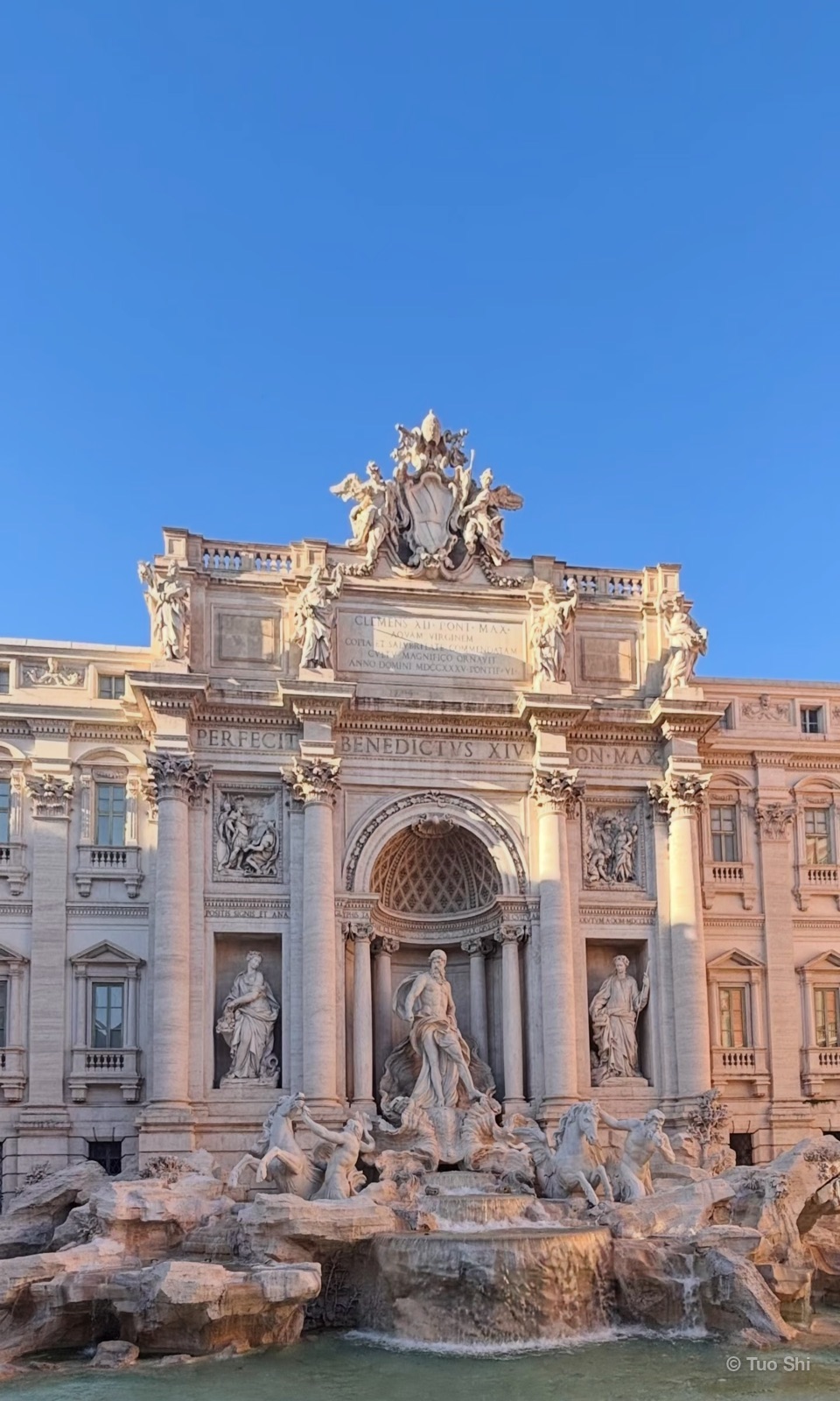 The Trevi Fountain and its marble statues in soft sunlight