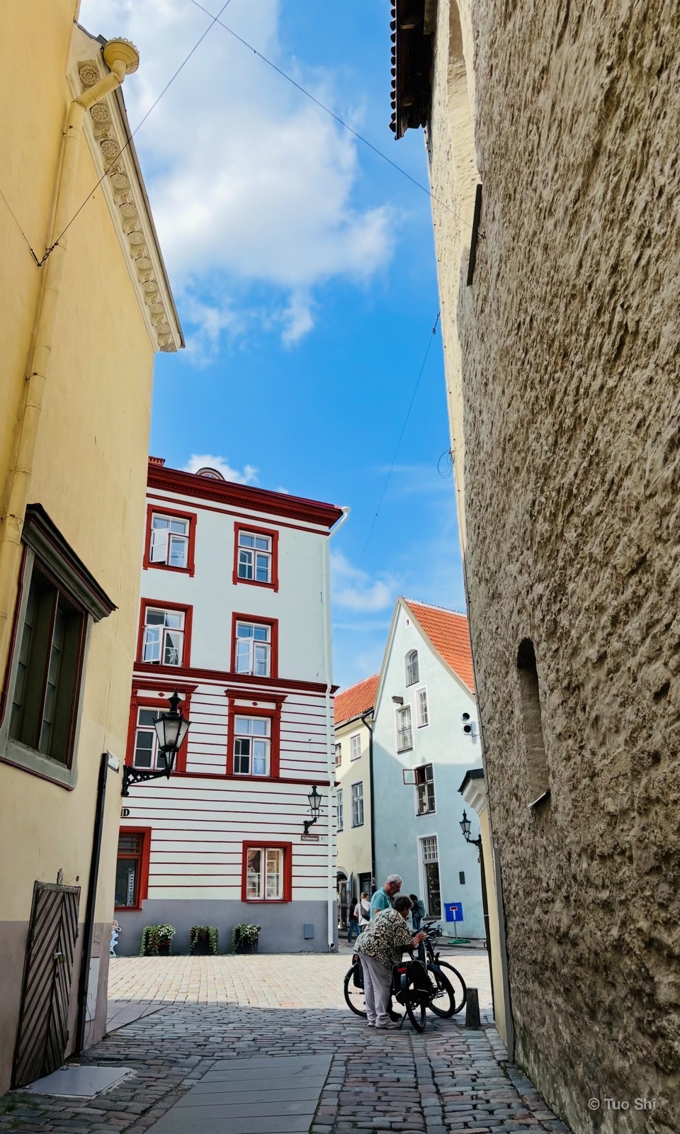 A cobbled lane in Tallinn Old Town beside a medieval stone wall